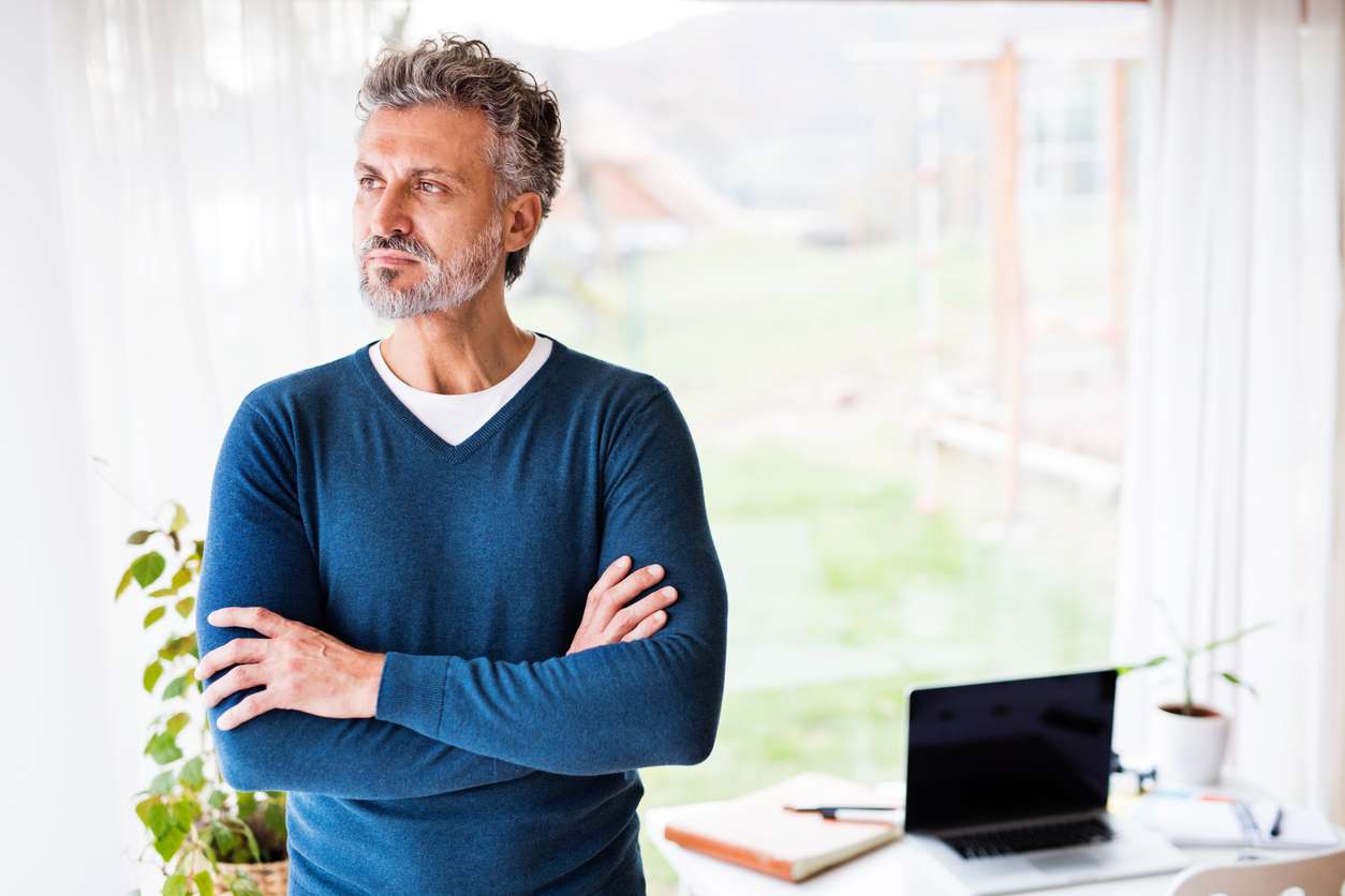 Man standing in office with arms crossed